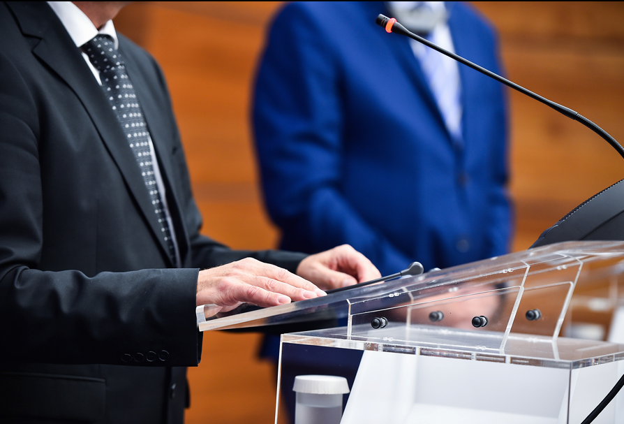 Liderança em púlpito com microfone — comunicação e estratégia política